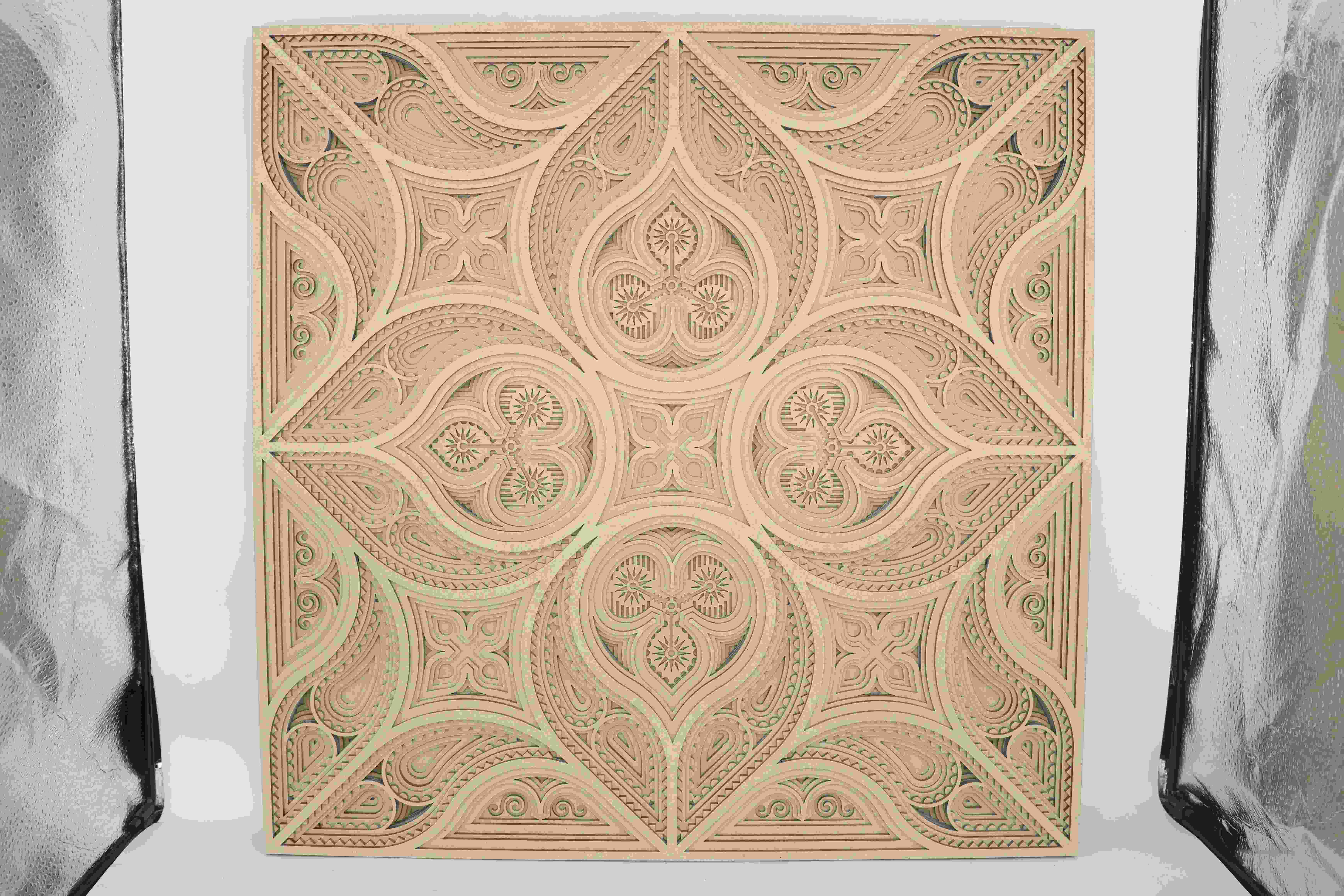 A layered wall art piece made from wood, precisely cut with a laser to form intricate patterns and clean edges